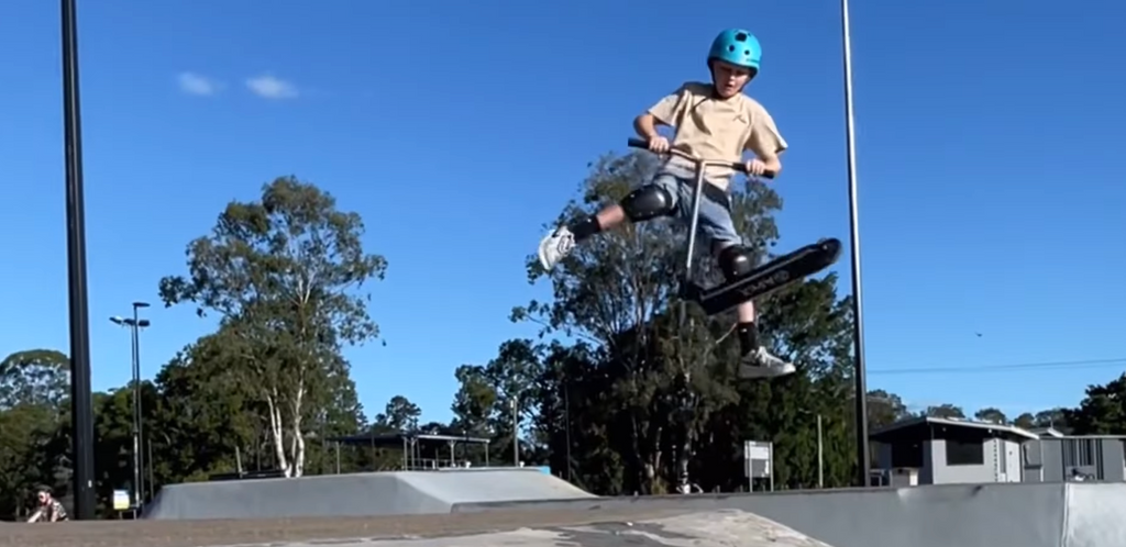 Scooter rider Olly at the skatepark doing tricks